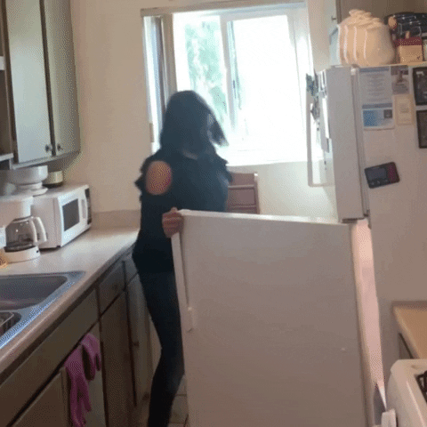 Una donna apre il frigo e sussulta per lo spavento